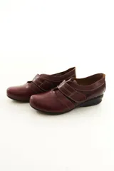 Zapato de cuero negro con cierre de velcro ancho y costuras pespunteadas a contratono.