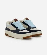 Championes casuales de estilo urbano con diseño de paneles en colores azul marino, beige y celeste. Presentan suela tipo caja de goma color crema con base marrón, cordones gruesos en color celeste y lengüeta acolchada.