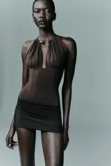 Body entallado de poliamida color marrón, con escote profundo y cuello metálico tipo choker integrado. Presenta un diseño sin mangas con frunces en el busto.