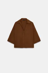 Camisa marrón de manga corta amplia, con cuello solapa y escote pico, cierre frontal con botones.
