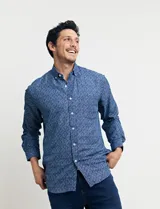 Camisa azul con estampado de lunares blancos, de manga larga y corte clásico.