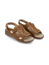Sandalias Hush Puppies modelo Juliana Tan, de cuero color marrón tostado con detalles de perforaciones láser en el empeine, costuras visibles y cierre con tiras autoadheribles. Cuenta con suela de goma con plataforma baja tipo cuña.