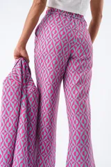 Pantalón fucsia con estampado geométrico en tonos celestes, de corte recto y cintura elástica fruncida.