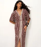 Vestido largo en piquet de viscosa color bordó con estampado geométrico en tono crudo, escote en V, mangas cortas amplias y tajo delantero. Incluye un cinturón de cuerda trenzada ajustable con detalles de borlas en la cintura.