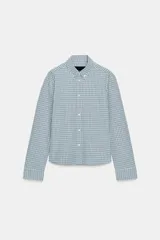 Camisa entallada de manga larga con cuello solapa y cierre frontal con botones. Presenta un diseño de estampado a cuadros en tonos azul y blanco.