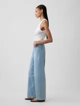 Jean de corte wide leg y tiro alto, en color azul claro con lavado desgastado. Presenta diseño de cinco bolsillos, cierre frontal con botón y cremallera, y costuras a tono.