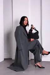 Bolso de nylon color naranja quemado, con textura sutil y manija fruncida. Presenta un parche rectangular negro con el logo 'KUL.' en blanco en el frente.