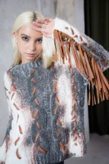 Sweater tejido a mano con diseño de ochos, con apliques de tiras de cuero entrelazadas y flecos en las mangas. Presenta un estampado artístico pintado a mano con efecto degradado en tonos blanco, gris y marrón.