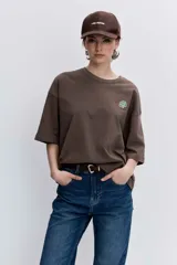 Remera blanca de corte oversize con cuello redondo y mangas cortas, presenta un pequeño bordado de cerezas en el pecho.