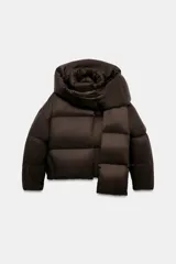 Campera puffer corta de color marrón oscuro, con diseño acolchado, cuello alto y capucha integrada. Presenta cierre frontal con botones magnéticos y mangas largas con puños elásticos.
