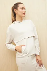 Canguro color beige de la línea Essence, con capucha, corte amplio y detalle de recorte frontal.