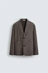 Blazer de corte relajado en color marrón oscuro, con cuello de solapas de muesca, cierre frontal de dos botones y bolsillos de plastrón en la parte delantera.