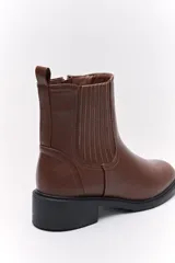 Botas tipo chelsea de caña baja, con laterales elastizados, tirador trasero y suela robusta.