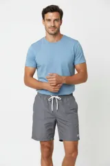 Short de baño de corte recto, confeccionado en poliéster, con cintura elástica ajustable mediante cordón y bolsillos laterales.