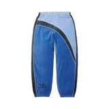 Pantalon de jogging Supreme x Umbro confeccionado en tejido de velour, de diseño colorblock en tonos azul, celeste y negro. Cuenta con cintura elastizada, puños en los tobillos, bandas laterales con ribetes y bordados de las marcas junto a un escudo en el frente.