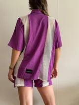 Camisa lila con paneles de red blanca en los laterales.