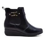 Botín negro de cuero con elásticos laterales, hebilla decorativa y plataforma baja.