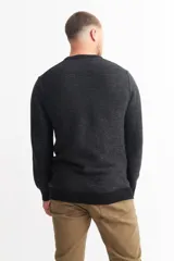 Sweater marrón de punto melange con cuello redondo y mangas largas.