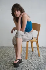 Pantalón capri de tiro medio con efecto lavado, bolsillos delanteros y traseros, y bajo con frunces laterales ajustables mediante cordones.