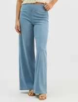 Jegging de tiro alto con silueta estilo palazzo y pierna amplia. Confeccionado en tejido denim con pretina ancha elástica, sin cierre frontal. Presenta diseño frontal liso sin bolsillos y dos bolsillos traseros tipo parche.