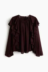 Blusa oversized de tejido transparente color bordó, con escote redondo fruncido, manga larga y ribetes de volados que se extienden desde el frente por los hombros hasta la espalda.