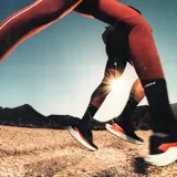 Championes de trail running Salomon DRX Defy Grvl, color negro con detalles en naranja y entresuela verde menta, diseñados con soporte y ligereza para correr en caminos de grava y asfalto.