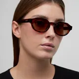 Lentes de sol con montura geométrica de acetato color carey (tortoise) y cristales marrones polarizados. El diseño combina una parte superior plana con una parte inferior redondeada.