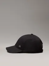 Gorra negra de algodón orgánico con logo CK metálico en el frente.
