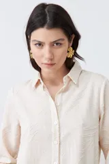 Camisa beige de manga larga con textura fantasía.