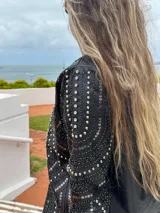 Chaqueta negra de cuero sintético con tachas plateadas, lentejuelas y strass.