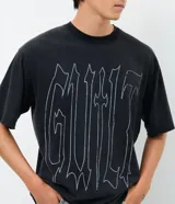 Remera masculina de corte boxy y calce amplio, color negro con estampa tipográfica "Guilt" en el frente. Cuenta con cuello redondo y mangas cortas.