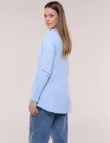 Cárdigan liviano blanco de punto acanalado, confeccionado en viscosa y elastano, con diseño de frente abierto, mangas largas entalladas y silueta fluida.