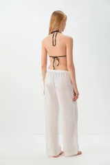 Pantalon de corte recto y holgado, confeccionado en una mezcla de lino y algodón. Presenta una cintura elástica con cordón ajustable y bolsillos laterales.