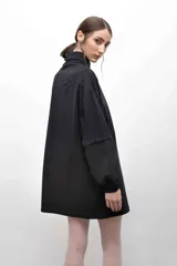 Remerón negro con cuello camisero, mangas largas con puños elásticos y bolsillo con solapa en el pecho.