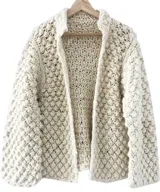 Cardigan de lana merino color beige, tejido a mano en punto garbanzo, con semi cuello alto y diseño abierto en la parte delantera.