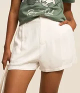 Short holgado de viscosa texturizada color blanco, con cintura de sastrería en la parte delantera y elástico en la trasera, bolsillos laterales y cierre con botón y cremallera.