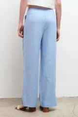 Pantalón color arena, de corte recto y tiro alto, confeccionado en lino.