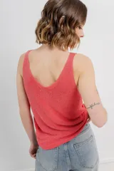 Musculosa tejida color amarillo pálido, con escote en V delantero y trasero.