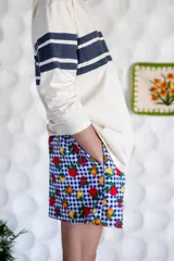 Short unisex de corte holgado con cintura elástica y estampado a cuadros rojos y blancos con dibujos de frutas.