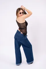 Remera asimétrica de un solo hombro color bordó, con cuerpo opaco y paneles de malla transparente en la cintura y en la manga larga.