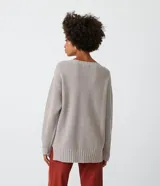 Suéter largo de punto texturizado color gris topo, con cuello redondo y mangas largas.