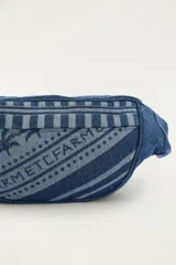 Riñonera confeccionada en poliéster con efecto denim, con estampado de palmeras, bandas geométricas y la inscripción "FARM". Cuenta con cierre de cremallera y correa ajustable con hebilla de plástico.