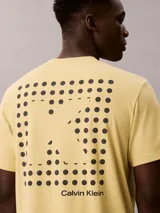 Remera Calvin Klein de manga corta y cuello redondo, color amarillo, con estampado gráfico frontal de líneas horizontales y la letra C en el centro.