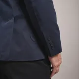 Saco de gabardina azul marino con solapa de muesca, dos botones frontales y bolsillos de parche.