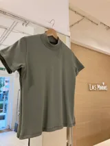 Polera blanca de morley con cuello alto y mangas cortas.