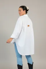 Camisa de algodón de corte oversize y calce relajado, con cuello camisero clásico, mangas largas con puños y ruedo irregular más largo en la parte posterior.