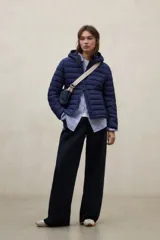 Campera puffer con capucha, color verde, diseño acolchado con costuras horizontales y cierre frontal.
