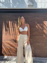 Pantalón beige de corte palazzo, con cintura elástica y diseño escalonado.