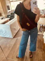 Riñonera de cuero con estampado animal print de vaca en blanco y negro, con correa regulable y cierre superior.