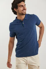 Remera polo de manga corta en color azul oscuro con estampado de pequeños puntos celestes. Presenta cuello clásico, cierre frontal con dos botones y terminaciones acanaladas en las mangas.